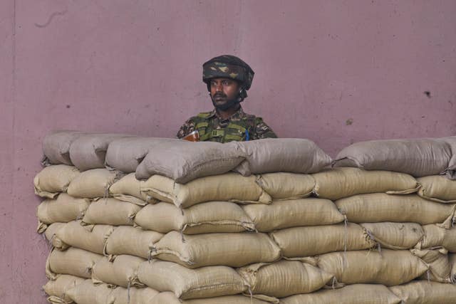 An Indian paramilitary soldier stands guard inside a bunker