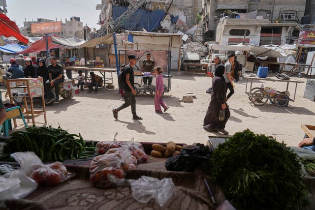 Palestinians purchase goods at a makeshift market in Khan Younis, Gaza Strip, on Sunday
