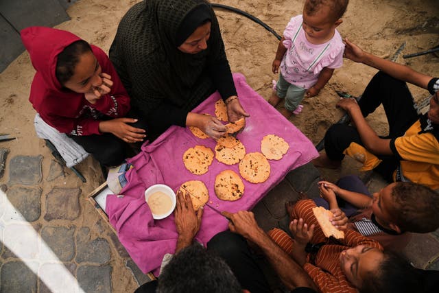 Nevin Qassim, a displaced Palestinian woman, and her family eat bread she baked from ground lentils 