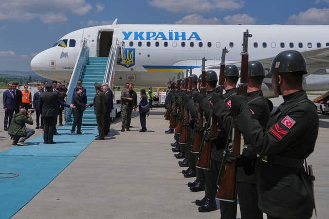 Ukrainian President Volodymyr Zelensky, centre left, is welcomed by Turkish officials upon his arrival at Esenboga airport in Ankara, Turkey