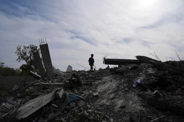 A Palestinian child walks in rubble 
