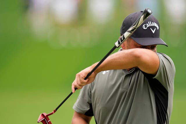Xander Schauffele wipes his face