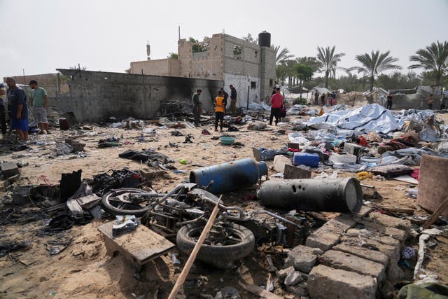 Palestinians inspect a site destroyed by Israeli airstrikes in Khan Younis