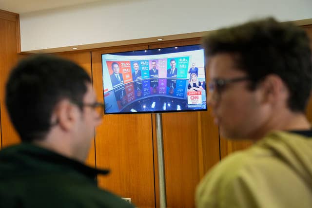 Socialist party supporters watch the announcement of the first exit polls on TV, following Portugal’s general election