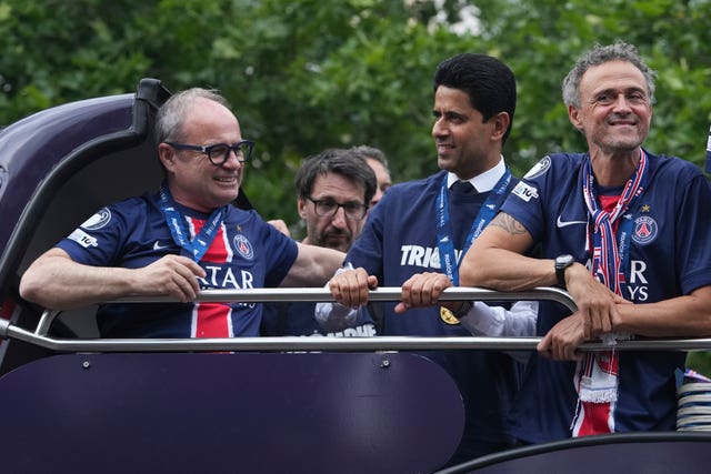 Paris St Germain head coach Luis Enrique, right, and club president Al-Khelaifi, centre, enjoy the trophy parade