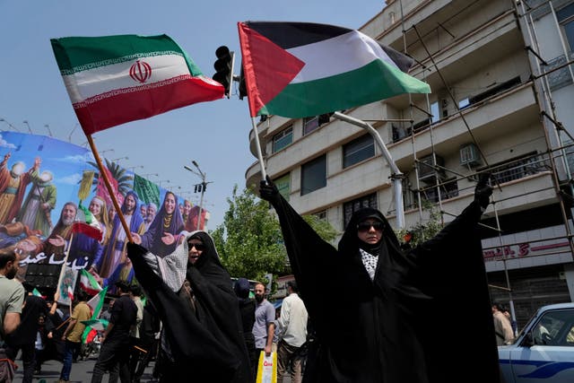 Iranian protesters hold up Iranian and Palestinian flags in an anti-Israeli gathering in Tehran