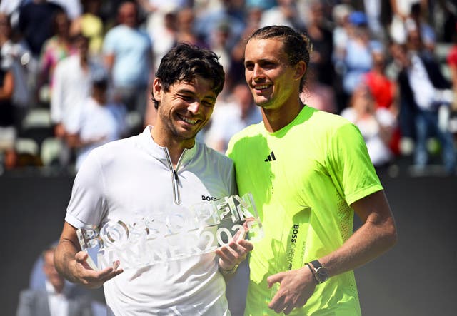 Taylor Fritz, left, holds the Boss Open trophy after beating Alexander Zverev, right, in the final in Stuttgart