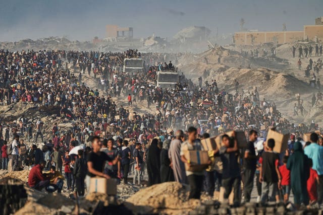 People carrying bags and boxes of food and humanitarian aid that was unloaded from a World Food Programme convoy that had been heading to Gaza City in the northern Gaza Strip