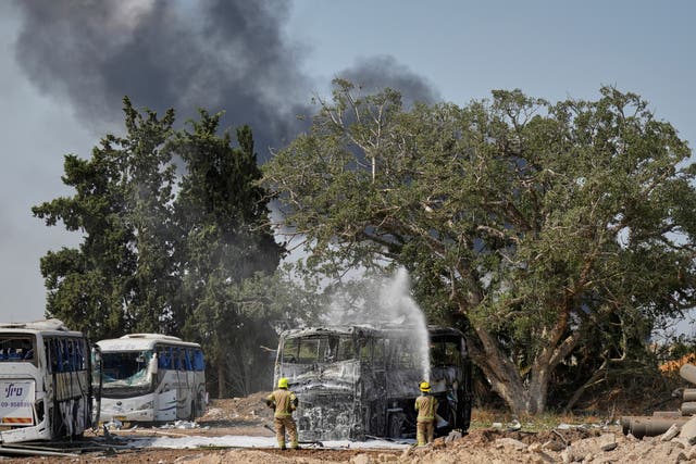 Firefighters work at a site in central Israel hit by a missile launched from Iran 