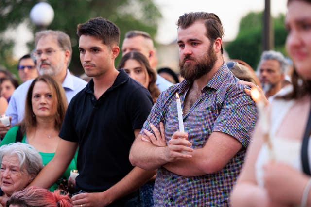 Colin Hortman (right) attends a candlelight vigil for his parents 