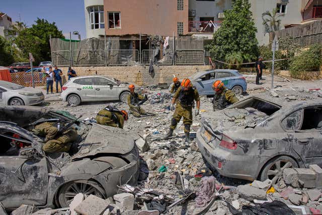 Israeli soldiers work amid the rubble of residential buildings destroyed by an Iranian missile strike that killed several people in Beersheba, Israel