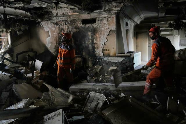 Workers clear rubble of a damaged building in Tehran, Iran
