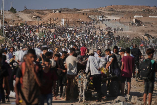 Palestinians carrying humanitarian aid packages near the Gaza Humanitarian Foundation distribution centre in Khan Younis, southern Gaza