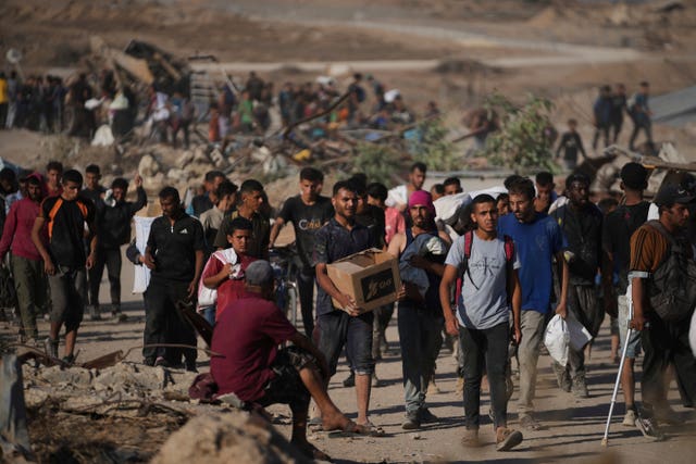 Palestinians carry humanitarian aid packages