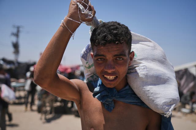 A Palestinian boy carries a sack of food