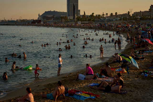 Swimmers leap into the sea on a hot day in Barcelona