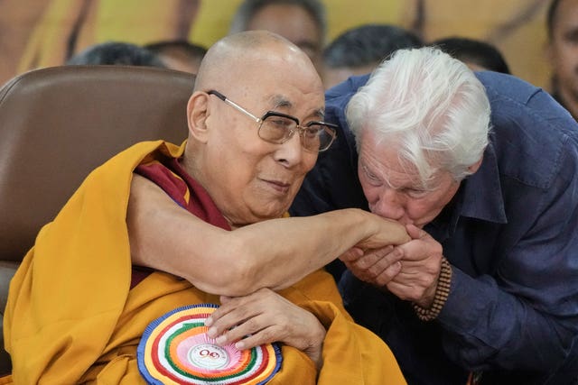 Actor Richard Gere, right, kisses the Dalai Lama's hand