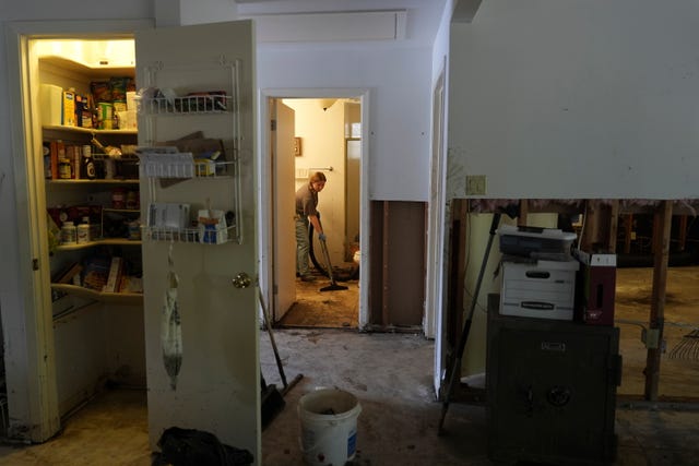 A volunteer helps clean up a house after the flooding in Kerrville, Texas 