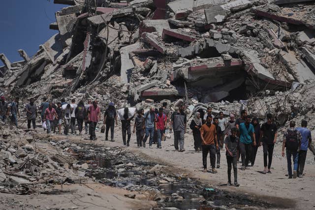 Palestinians carry sacks of humanitarian aid unloaded from trucks that had been heading to Gaza City, in the northern Gaza Strip on Sunday 