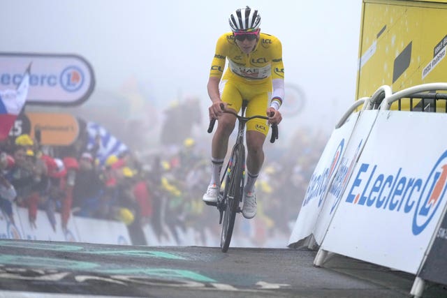 Tadej Pogacar crosses the finish line of stage 18 in the yellow jersey