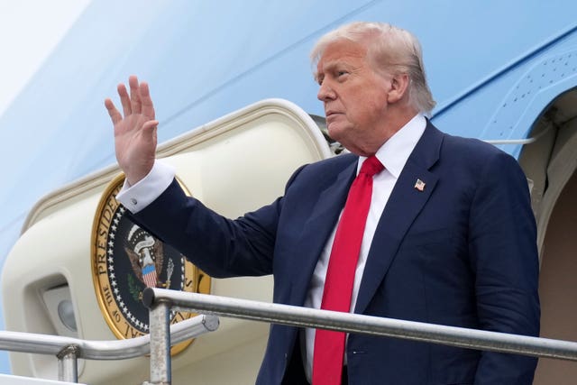 Donald Trump waves as he disembarks from Air Force One