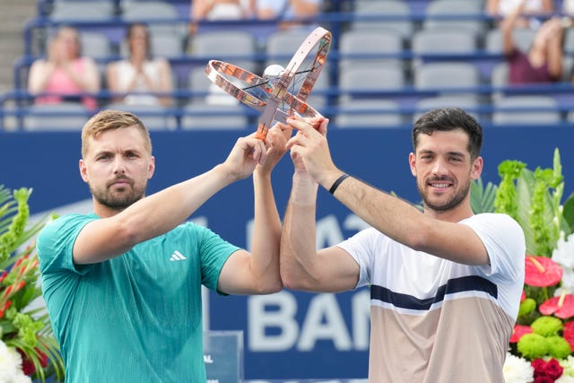 Lloyd Glasspool, left, and Julian Cash, of Britain, right, lift the men’s doubles trophy after defeating Joe Salisbury and Neal Skupski