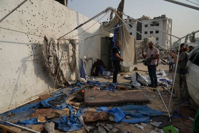 People inspect the destroyed tent where journalists, including Al Jazeera correspondents Anas al-Sharif and Mohamed Qreiqeh, were killed by an Israeli air strike