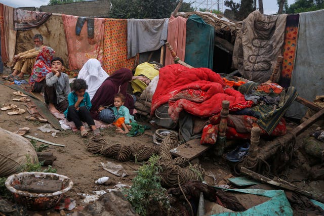 Villagers sit over the rubble of their damaged home in Pir Baba, an area of Buner district, in the north-west of Pakistan 