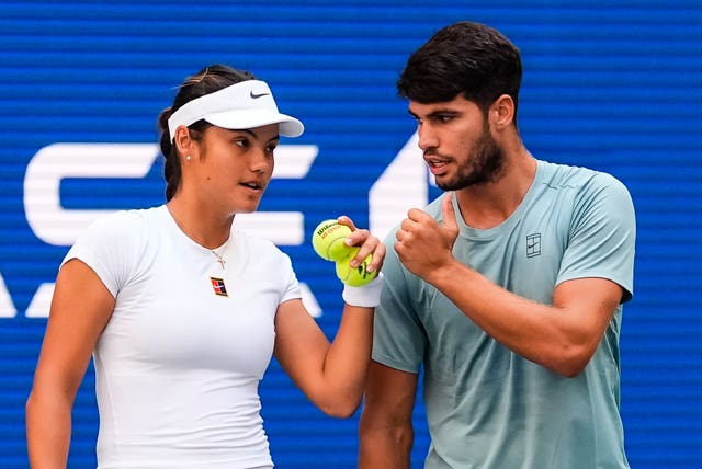 Carlos Alcaraz, right, and Emma Raducanu talk during their match