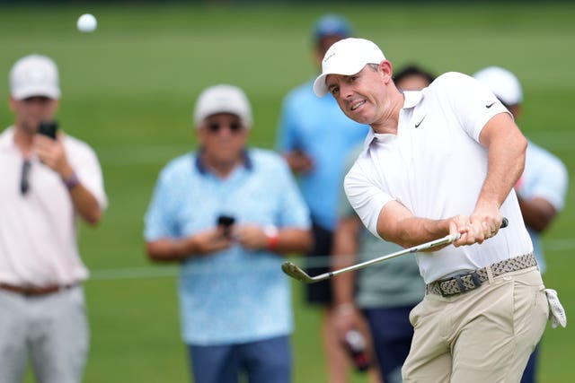 Rory McIlroy chips to the first green during the first round of the Tour Championship
