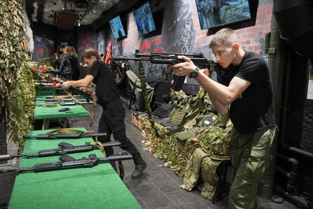 Young men practise with Kalashnikov assault rifles at a museum of Russian Special Military Operations in Ukraine in St Petersburg, Russia 