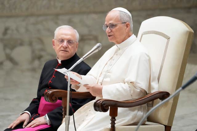 Pope Leo seated while speaking into a microphone