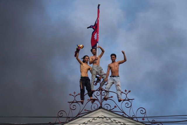 Protesters stand at the top of the Singha Durbar, the seat of Nepal’s government’s various ministries and offices in Kathmandu 