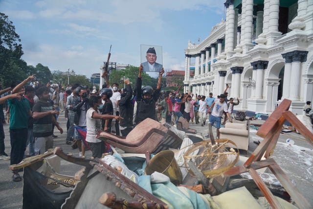 A protester throws a photograph of Nepal Prime Minister Khadga Prasad Oli outside the Singha Durbar