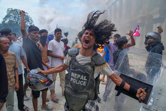 A protester wearing a flak jacket and carrying a shield snatched from a policeman in Kathmandu 
