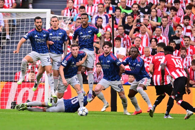 Arsenal players jump as Athletic Bilbao’s Adama Boiro, right, prepares to shoot a free kick 