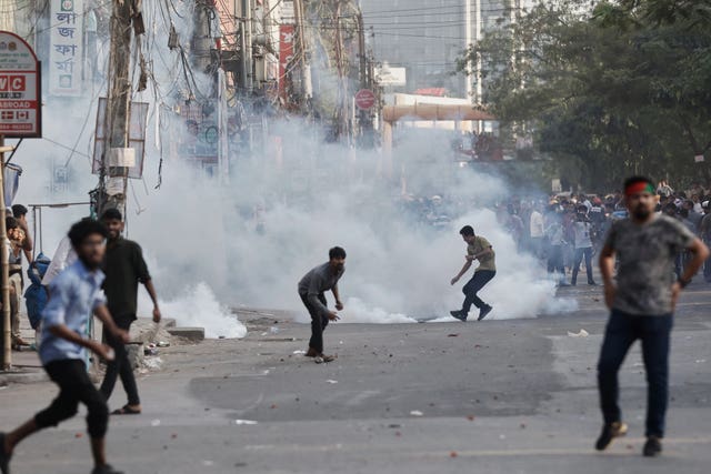 Protesters throw stones and shout slogans during a standoff with police outside the demolished residence of Sheikh Mujibur Rahman, Bangladesh’s former leader and the father of the country’s ousted prime minister Sheikh Hasina following the verdict against her, in Dhaka, Bangladesh