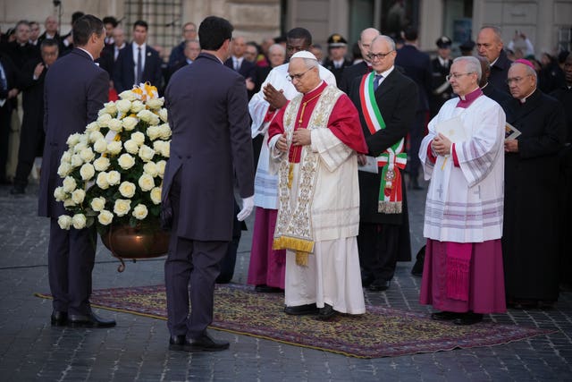 The pope with a big bouquet of white roses