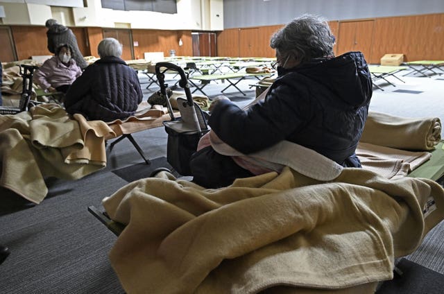 Evacuees sat on makeshift beds and chairs get ready to return home as a tsunami advisory has been lifted in Hidaka town, northern Japan 