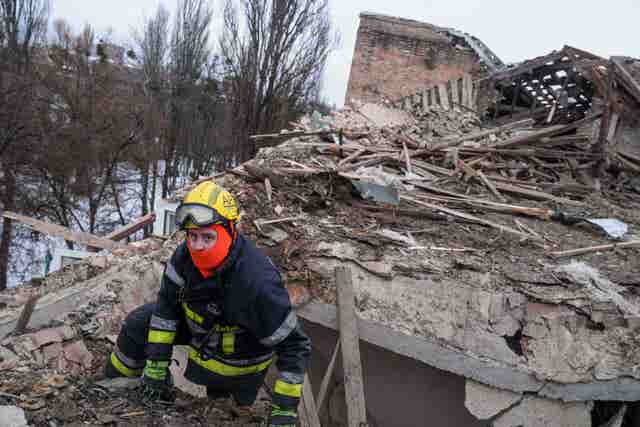Rescue worker amid rubble of destroyed building