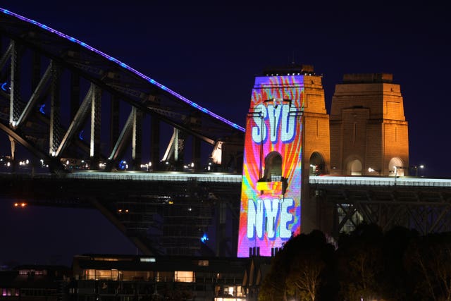 A colourful sign is projected onto Sydney Harbour Bridge
