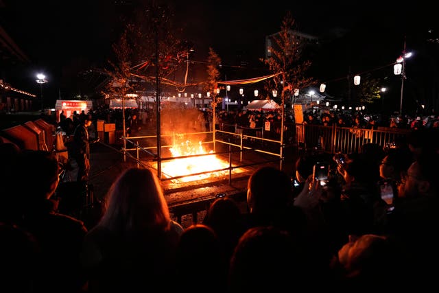 People burn old resolutions at the Zojoji Buddhist temple, minutes after midnight, in Tokyo