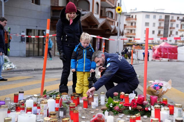 A police officer helping a boy to light a candle