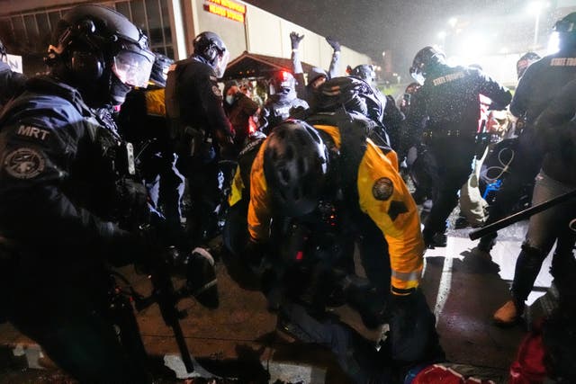 Law enforcement move to detain protesters outside the US Immigration and Customs Enforcement facility in Portland