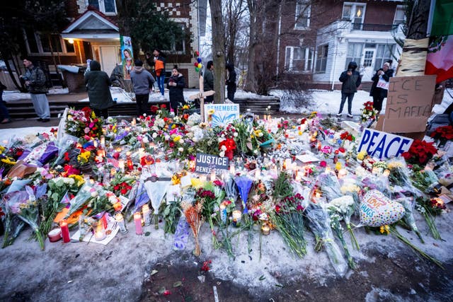People pay their respects at a memorial honouring a woman who was fatally shot in Minneapolis