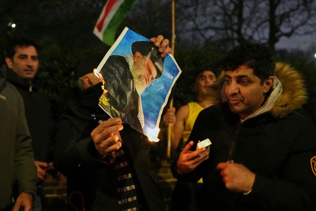 A picture of Iran's supreme leader Ayatollah Ali Khamenei is set alight by protesters outside the Iranian embassy in London 