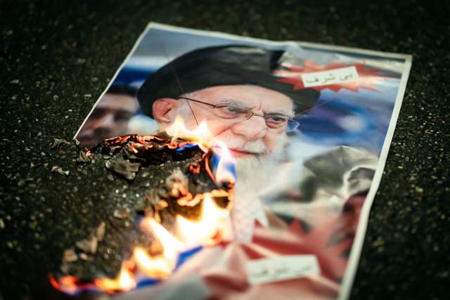 A burning image of the Ayatollah Ali Khamenei is seen during rally in Switzerland in support of the protests in Iran (Michael Buholzer/AP)