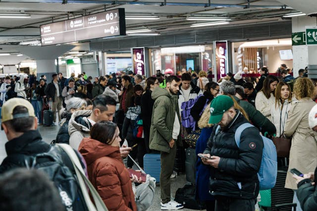 Passengers wait in the hall of Madrid train station