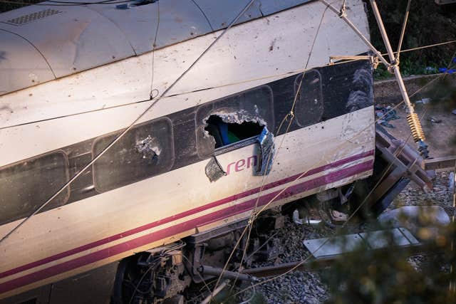 Part of a wrecked train is photographed at the site of the train collision in Adamuz, southern Spain