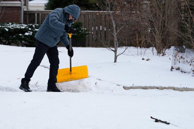 A person shovelling snow during cold weather in Evanston, Illinois